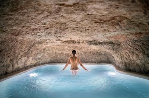Un uomo in una piscina in una grotta di El Bálsamo - Hotel Boutique 5 Estrellas a Belmonte