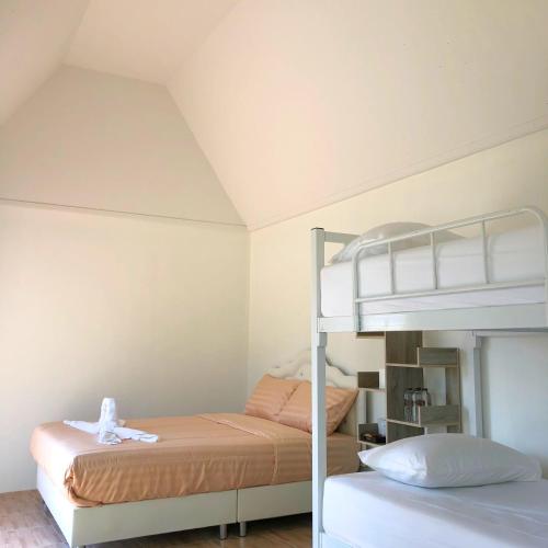 una camera con 2 letti e un letto a castello di Quality Time farm stay: Yard house a Ban Pa Lau