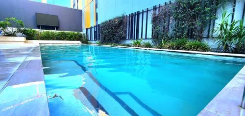 a swimming pool with blue water in front of a building at Room in shared apartment in Fortitude Valley in Brisbane