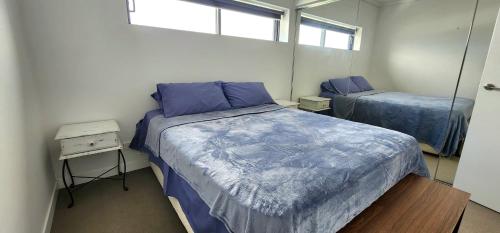 a bedroom with two beds and a mirror at Room in shared apartment in Fortitude Valley in Brisbane