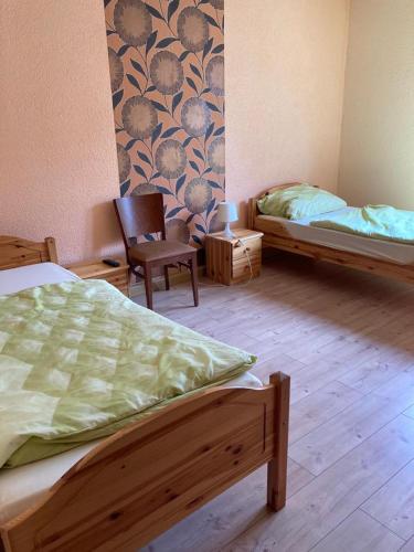 Un dormitorio con 2 camas y una silla. en Monteurunterkunft Oberhausen-Rheinhausen, en Oberhausen-Rheinhausen