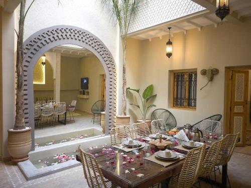 uma sala de jantar com mesa e cadeiras e um arco em Magnifique Riad Privatif Kasbah em Marrakech