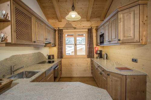 a large kitchen with wooden cabinets and a sink at Ferienwohnung Tegernsee,Fam Schneider, Kreuth-Grüneck in Kreuth