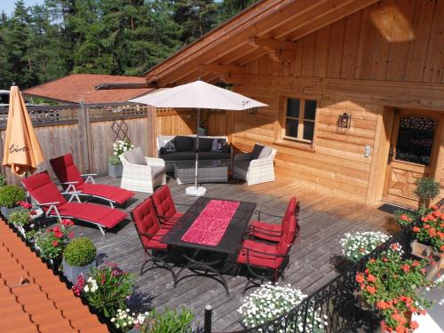 a patio with a table and chairs and an umbrella at Ferienwohnung Tegernsee,Fam Schneider, Kreuth-Grüneck in Kreuth