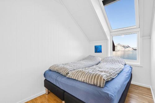 łóżko w pokoju z oknem w obiekcie Nappstraumen Seafront Cabin, Lilleeid 68 w mieście Gravdal