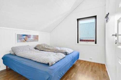 a white room with a blue bed in it at Nappstraumen Seafront Cabin, Lilleeid 68 in Gravdal