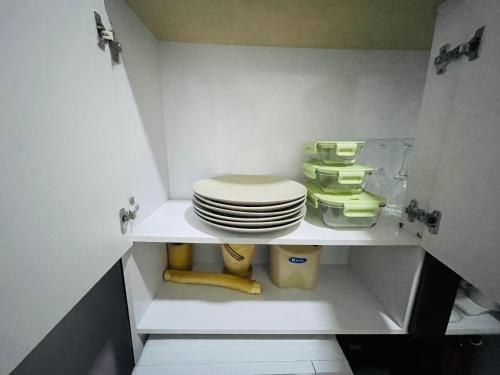 a small bathroom with a toilet and a stack of plates at Luanda City Hostel in Luanda