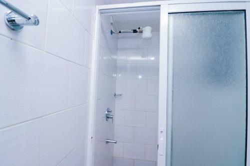 een douche met een glazen deur in de badkamer bij Shyrah Havana in Nairobi