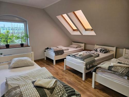 a room with three beds and a skylight at Noclegi Sławomir Zabłocki Bydgoszcz/Nakło nad Notecią i okolice in Strzelewo