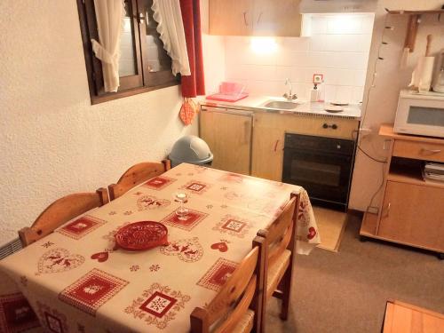 une cuisine avec une table et un tissu de table chinois dans l'établissement La Montagne, à Le Biot