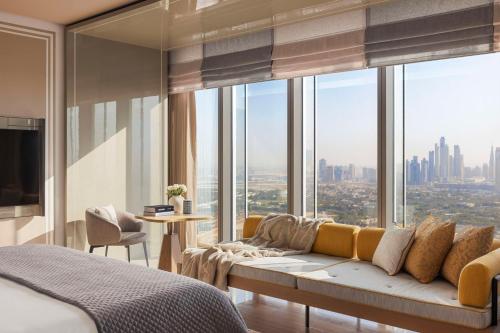 a bedroom with a couch in front of a large window at One&Only One Za'abeel in Dubai