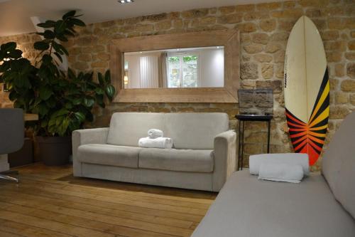 een woonkamer met een bank en een surfplank bij Hot Hot Hot Loft Faubourg Saint-Denis in Parijs