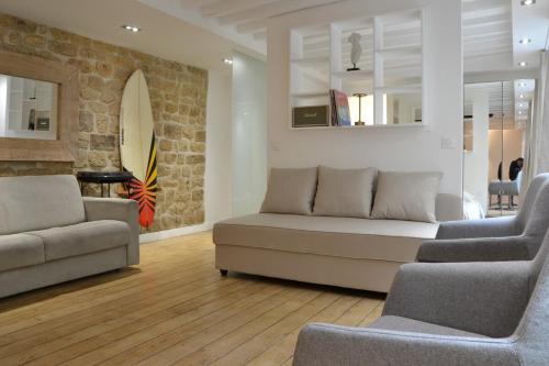 una sala de estar con 2 sofás y una pared de piedra. en Hot Hot Hot Loft Faubourg Saint-Denis, en París