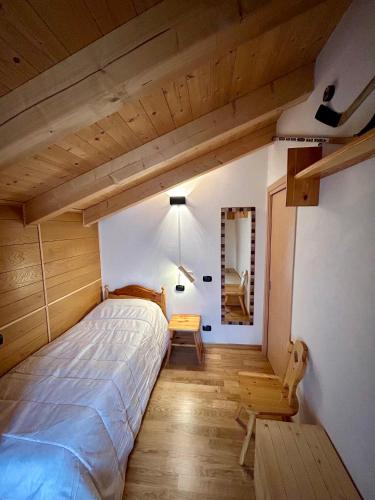 een slaapkamer met een groot bed en een trap bij Auronzo - appartamento centrale vista mozzafiato in Auronzo di Cadore