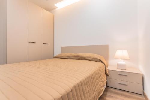 a bedroom with a bed and a night stand with a lamp at Chic Retreat in the Heart of Tigne Sliema in Sliema