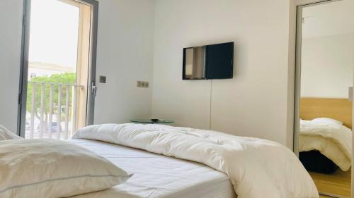 - une chambre avec un lit et une télévision murale dans l'établissement Appartement les Carolines Calvi, à Calvi