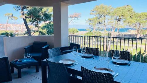 - une table avec des verres à vin sur le balcon dans l'établissement Appartement les Carolines Calvi, à Calvi