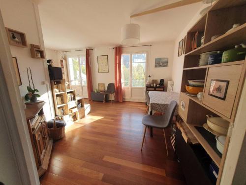 ein Wohnzimmer mit Holzboden und ein Esszimmer in der Unterkunft Chambre privée au calme chez l'habitant in Montrouge