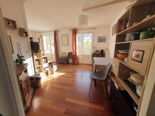 a living room with a wooden floor and a dining room at Chambre privée au calme chez l'habitant in Montrouge