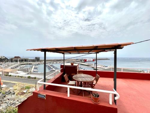 un patio con mesa y sillas en la azotea en Atico de 2 dormitorios con vista al Mar, a 100 m de playa, en Puerto de la Estaca