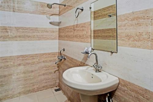 y baño con lavabo y espejo. en Hotel Imperial, en Greater Noida