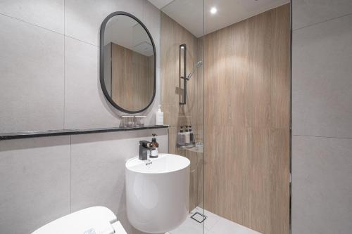 a bathroom with a white toilet and a mirror at Hotel 701 Gyeongju in Gyeongju