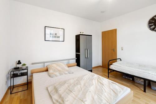 um quarto branco com uma cama e um frigorífico em Wohnen am Wissenschaftshafen em Magdeburg
