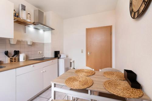 a kitchen with a wooden table and chairs in a room at Wohnen am Wissenschaftshafen in Magdeburg