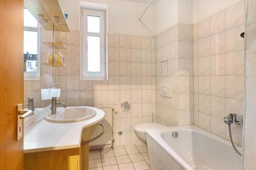 uma casa de banho com um lavatório, uma banheira e um WC. em Wohnen am Wissenschaftshafen em Magdeburg