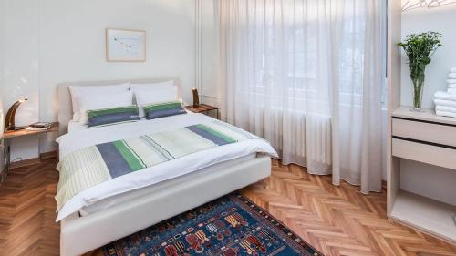 a white bedroom with a bed and a window at Apartment Balkan in Belgrade