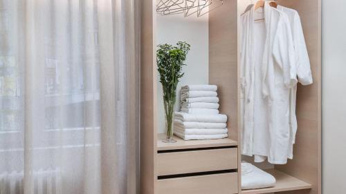a closet with a white shower curtain and a shelf with towels at Apartment Balkan in Belgrade