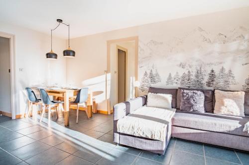 un salon avec un canapé et une salle à manger dans l'établissement Les Tussilages - Terrasse vue Mont-Blanc, à Chamonix-Mont-Blanc