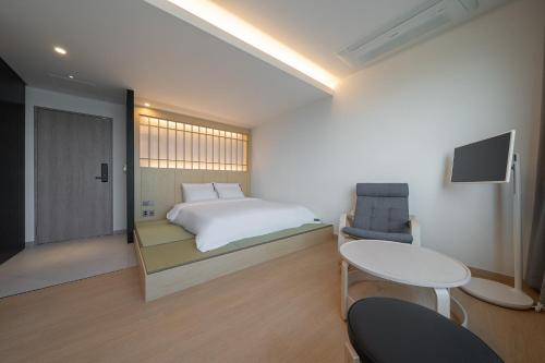 慶州的住宿－Hotel 701 Gyeongju，卧室配有1张床、1张桌子和1把椅子