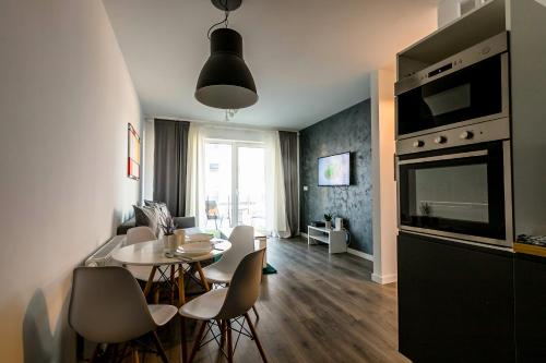 eine Küche und ein Wohnzimmer mit einem Tisch und Stühlen in der Unterkunft Old School Apartament in Bolesławiec