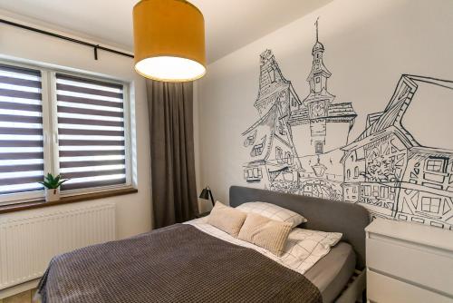 Schlafzimmer mit einem Bett mit Wandzeichnung in der Unterkunft Old School Apartament in Bolesławiec