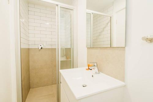 a white bathroom with a sink and a shower at 301 Le Jardin in George