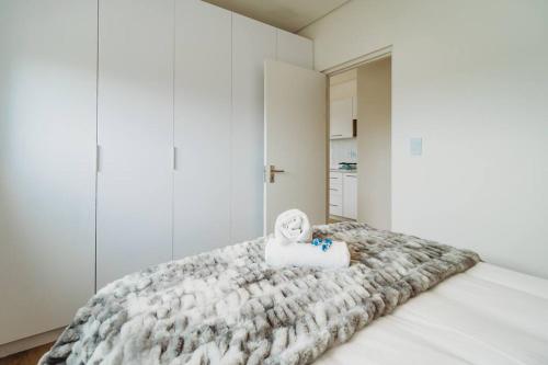 una habitación blanca con una cama con una toalla encima. en 301 Le Jardin, en George