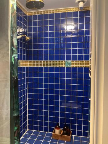 a blue tiled shower with blue tiles in a bathroom at Snällfäll Country living - Åkerbo gård charmigt renoverad flygel in Kristinehamn