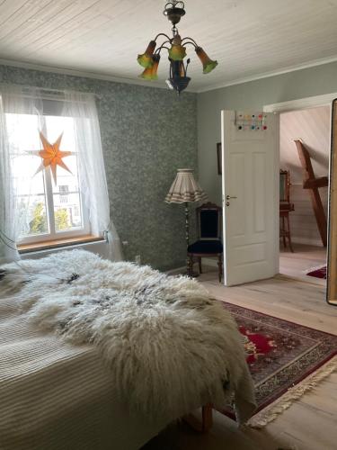 a bedroom with a white bed and a window at Snällfäll Country living - Åkerbo gård charmigt renoverad flygel in Kristinehamn