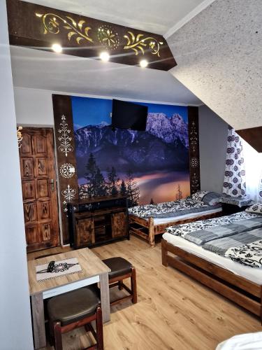 two beds in a room with a painting on the wall at Pokoje Gościnne U Moniki i Daniela in Zakopane