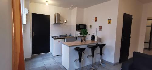 uma cozinha com um balcão com bancos pretos em Appartement tendance en plein coeur de Mâcon E em Mâcon