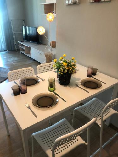une table avec trois assiettes et des fleurs au-dessus dans l'établissement Apartment Festival, à Pomorie