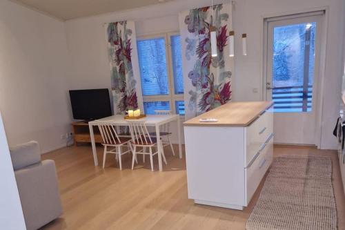 una cucina con scrivania, tavolo e TV di 2BR and LuxurySauna a Tornio