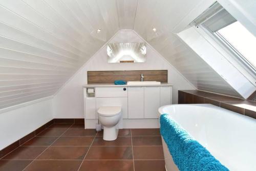 y baño con aseo, lavabo y bañera. en Impeccable 2-Bed Cottage in Johnshaven, en Montrose
