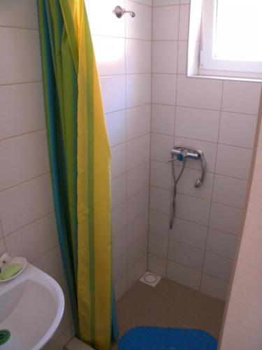 a bathroom with a rainbow shower curtain next to a sink at Penzión Anika in Krásnohorská Dlhá Lúka