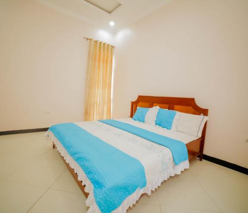 a bedroom with a bed with blue and white sheets at The Palaixon in Bujumbura