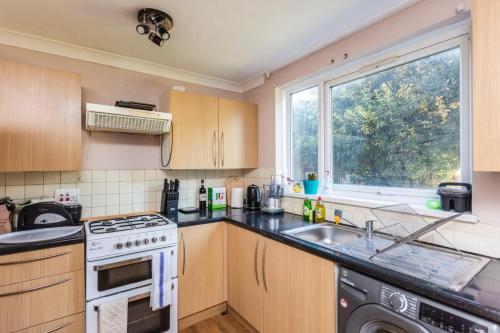 a kitchen with a stove and a sink and a window at Spacious 2BD House wPrivate Garden - Kennington! in London