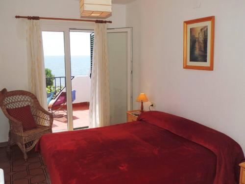 a bedroom with a bed and a balcony with the ocean at Lliri - Adosado en l'Ampolla en primera línea de mar - Deltavacaciones in L'Ampolla