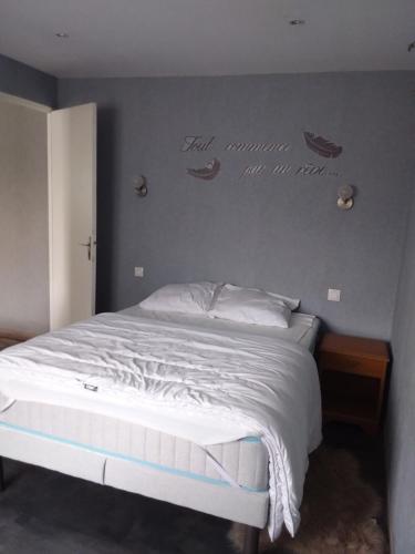 a bed in a bedroom with a wall with two shoes on it at L’ambroise in Pendé