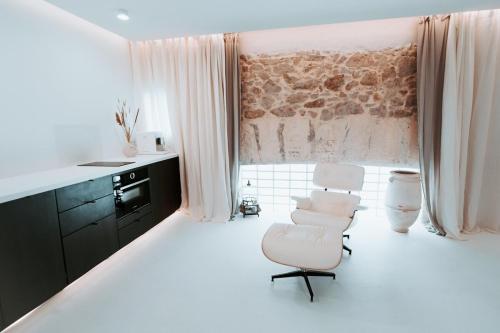 uma cozinha branca com uma cadeira branca e uma mesa em AAA Love & Balneo Week-End em Marselha
